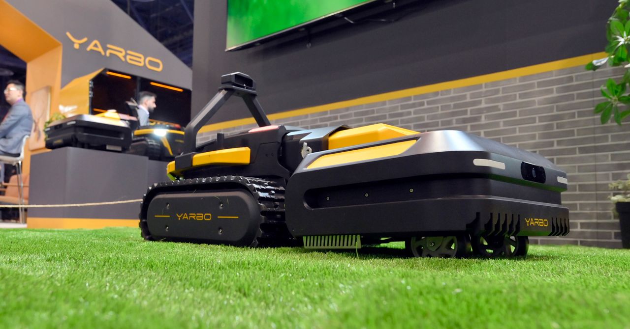 A menacing-looking robot lawn mower sits in a manicured yard, its blades glinting under the sun.