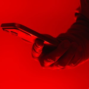 Smartphone displaying WhatsApp with a malicious QR code overlay and warning alert