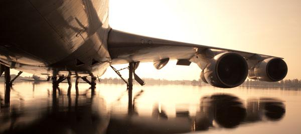 飛行機のチケットがデジタルのウイルスに変化する様子の様式化されたグラフィック。偽の旅行予約がマルウェアを配信することを象徴している。